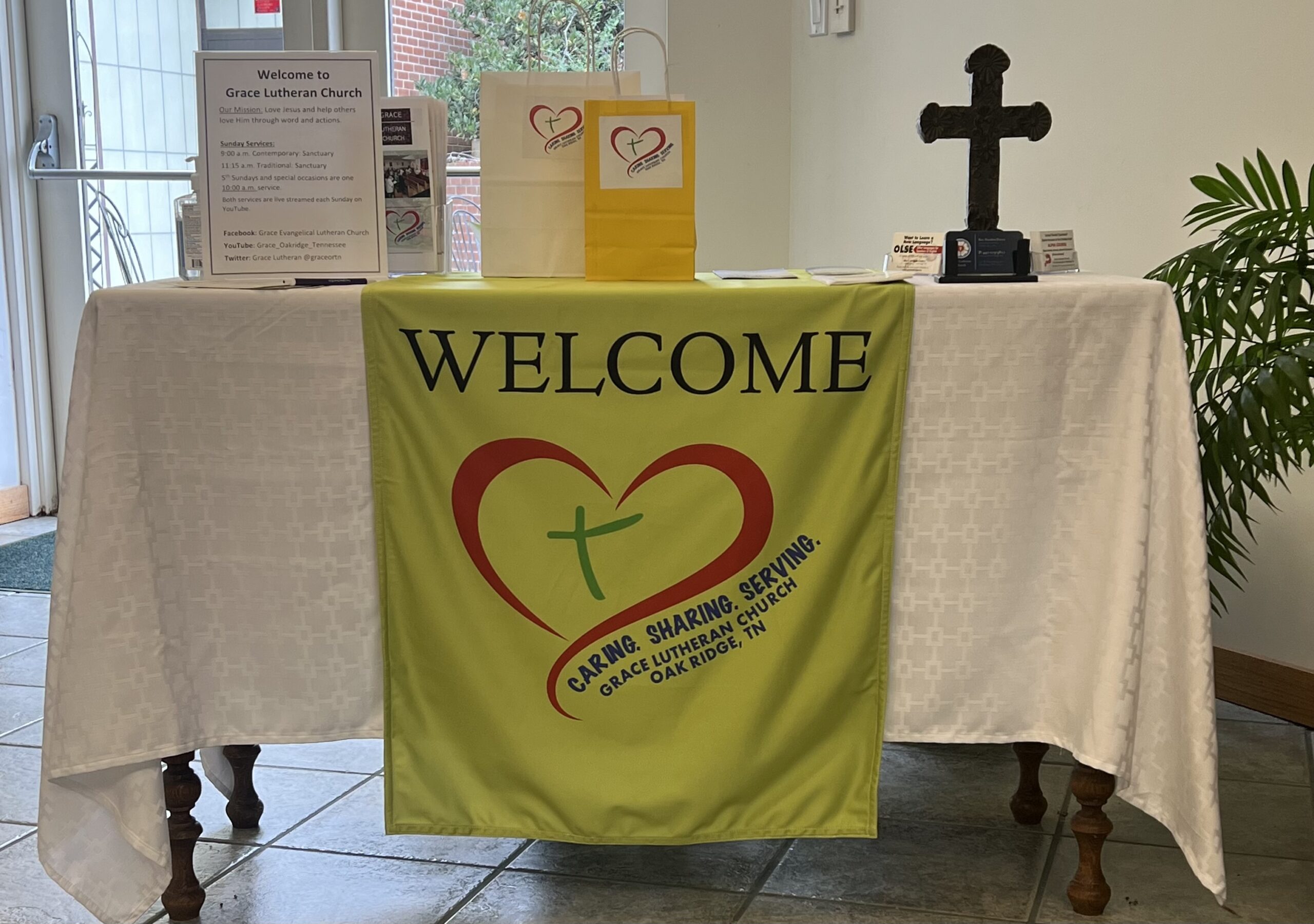 Table covered with a white cloth with a welcome banner hanging from the front